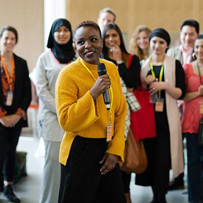 Association mobile 400x400px female speaker address group at an association forum