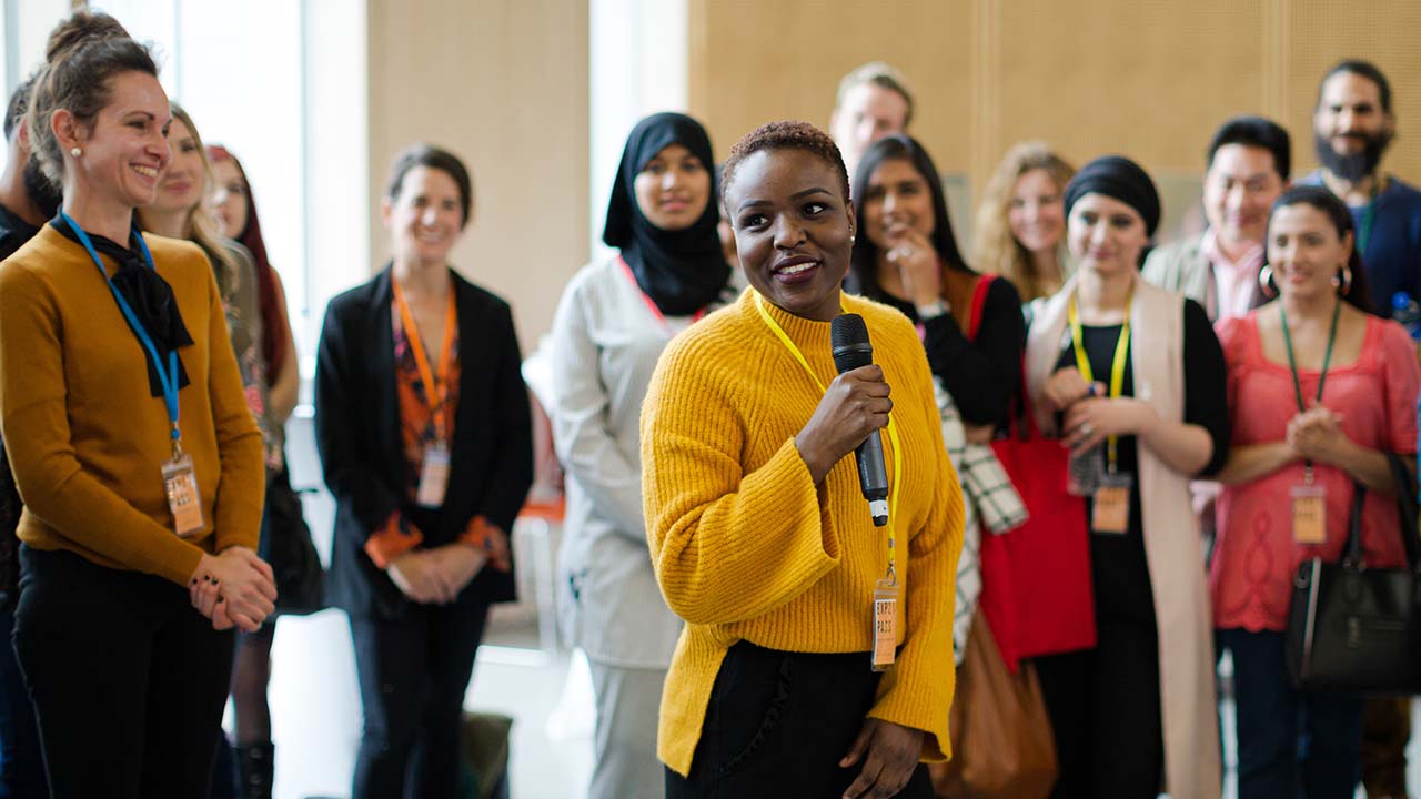 Associations 1280x720px female speaker address group at an association forum