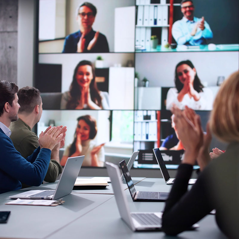 Bespoke Landing Page 800x800px group of people in meeting room using videoconferencing to enage other work collegues remotely<br />
