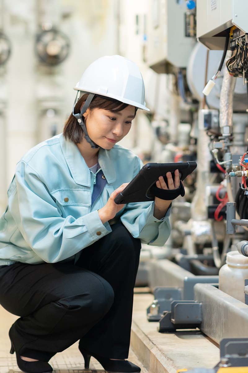 Bespoke solution module 800x1200px Female asian with hard hat on in industrial plant checking equipment with laptop