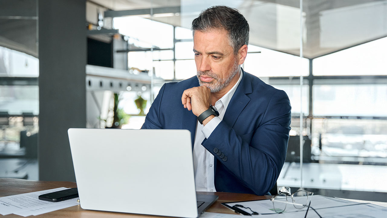Executive learning 1280x720px male professional siting in front of laptop engages with an executive learning course