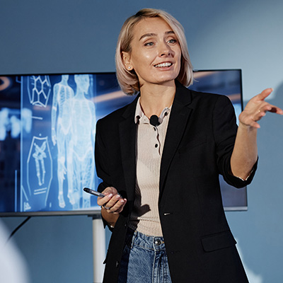 Extended Learning mobile 400x400px female presenting in front of monitor with human visual