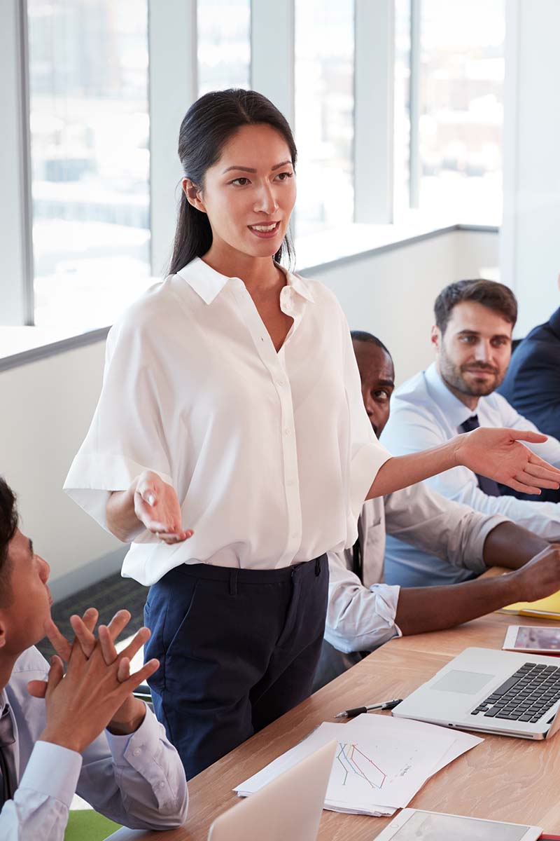 Lift Header 800x1200px Asian lady standing up and presenting to a room of employees