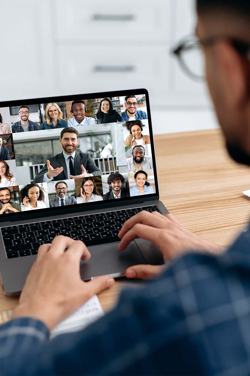 Portal Header 800x1200px Male viewing laptop with group of people on video conference