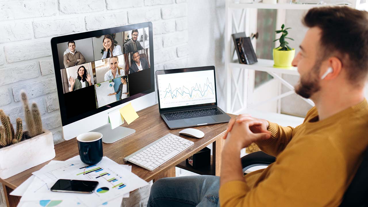 launch & Scale 1280x720px male in home office videoconferencing team of people shown on laptop