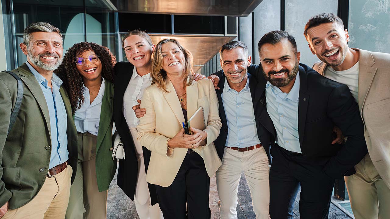 Group of happy and smiling corporate employees neatly dressed, taking a team photo