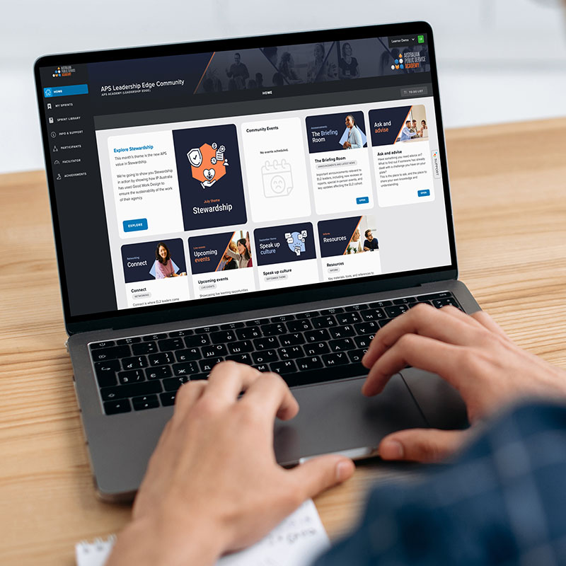 Homepage 400x400px looking over the shoulder of a male at his laptop which has the Cahoot Learning portal on screen