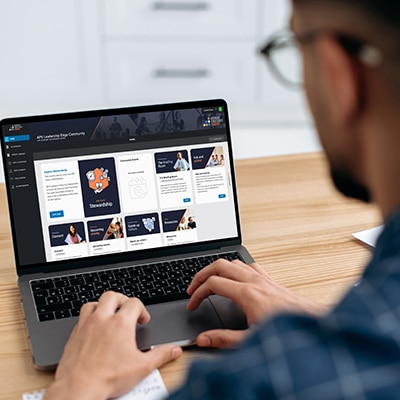 Female and male in front of laptop in meeting room discussing content on screen